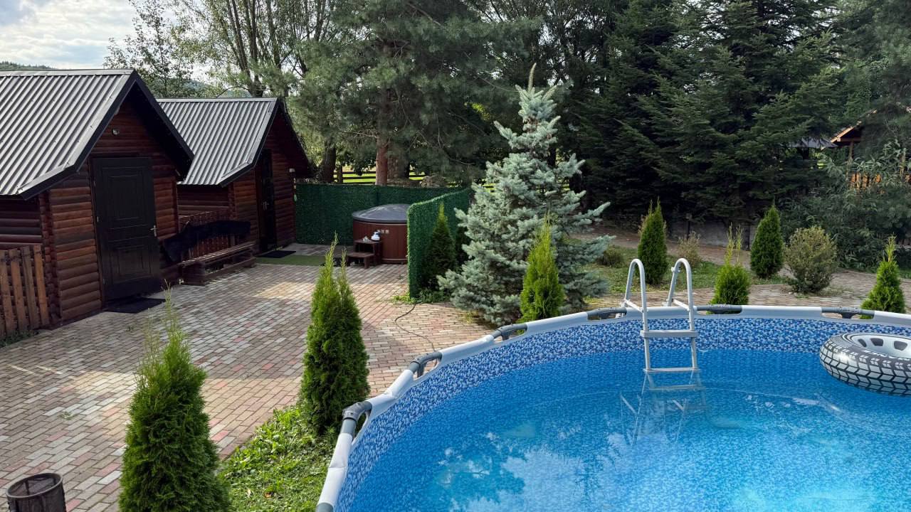 Басейн і дерев'яні будиночки на території
