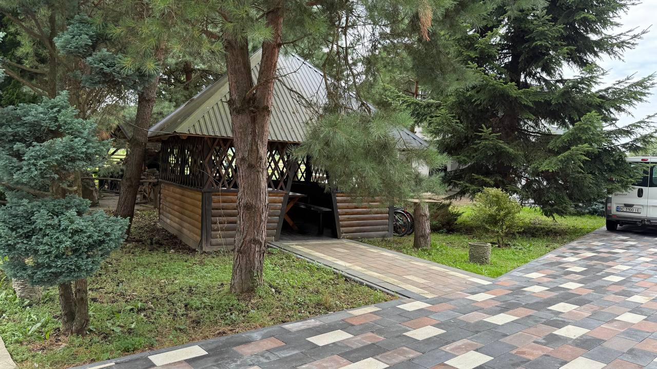 Дерев'яна альтанка біля вимощеної доріжки